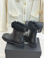 Black leather ankle boots with black faux-fur cuffs and ankle tab zipper pull