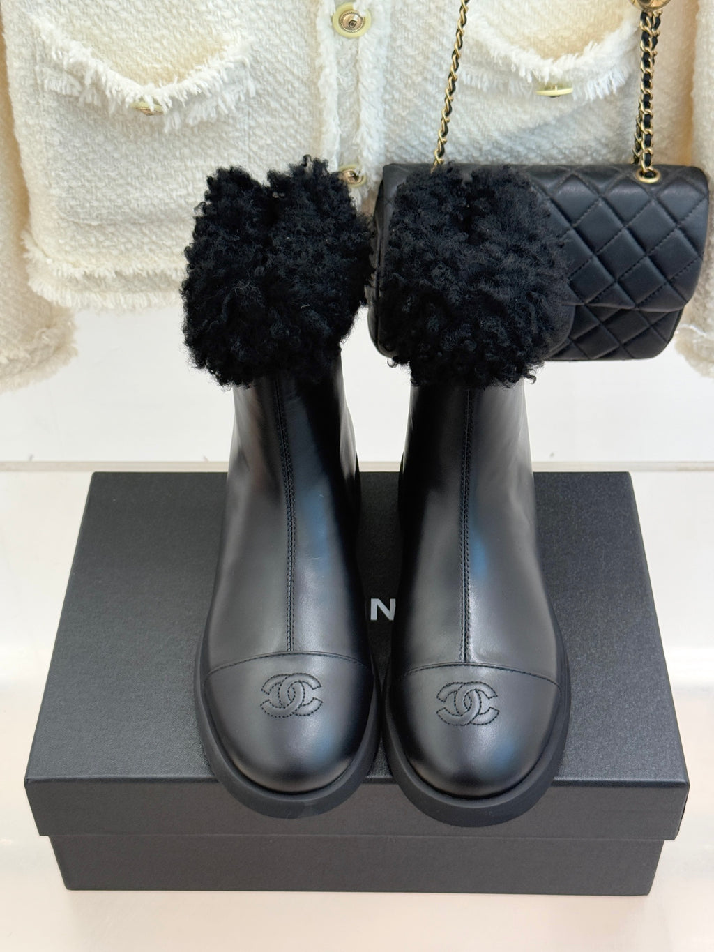Black leather ankle boots with faux-fur cuffs and stitched round-toe design