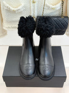 Black leather ankle boots with faux-fur cuffs and stitched round-toe design