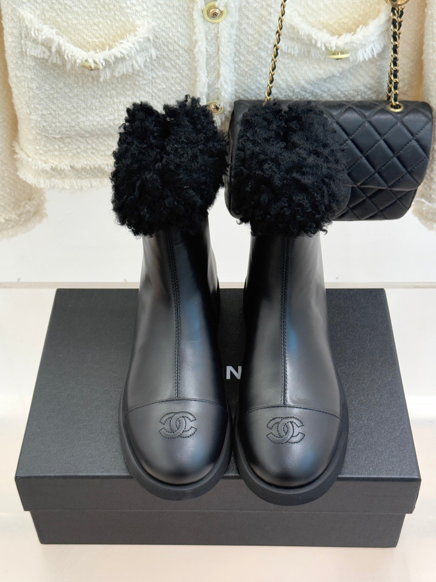 Black leather ankle boots with faux-fur cuffs and stitched round-toe design