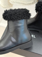 Close-up of black leather ankle boot with black faux-fur cuff and rounded toe