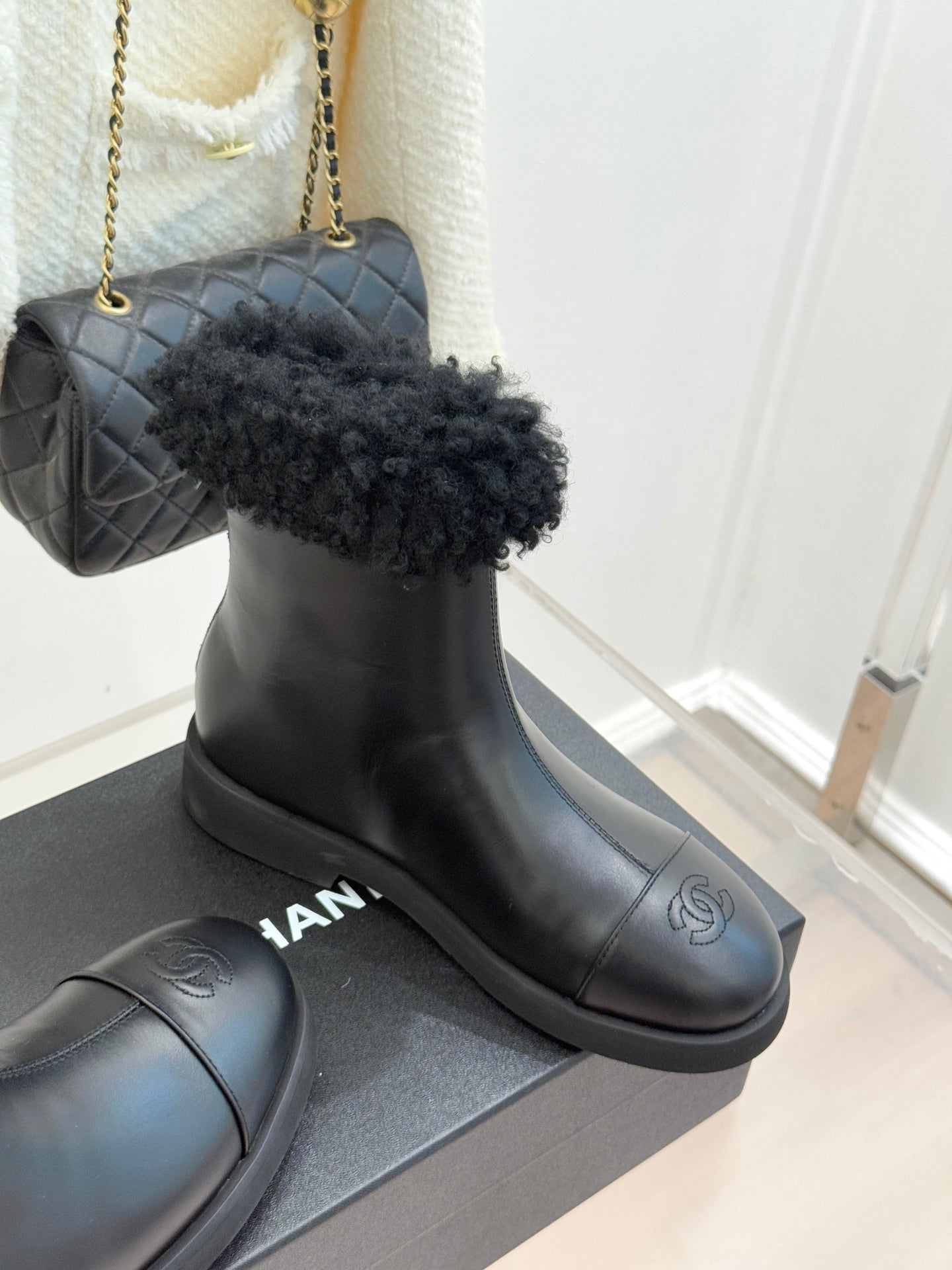 Black leather ankle boots with black faux-fur cuffs on a flat rubber sole