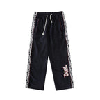 Navy drawstring pants with white drawcord and patterned logo side stripes