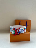 White graphic belt with large red LV buckle on a smooth strap