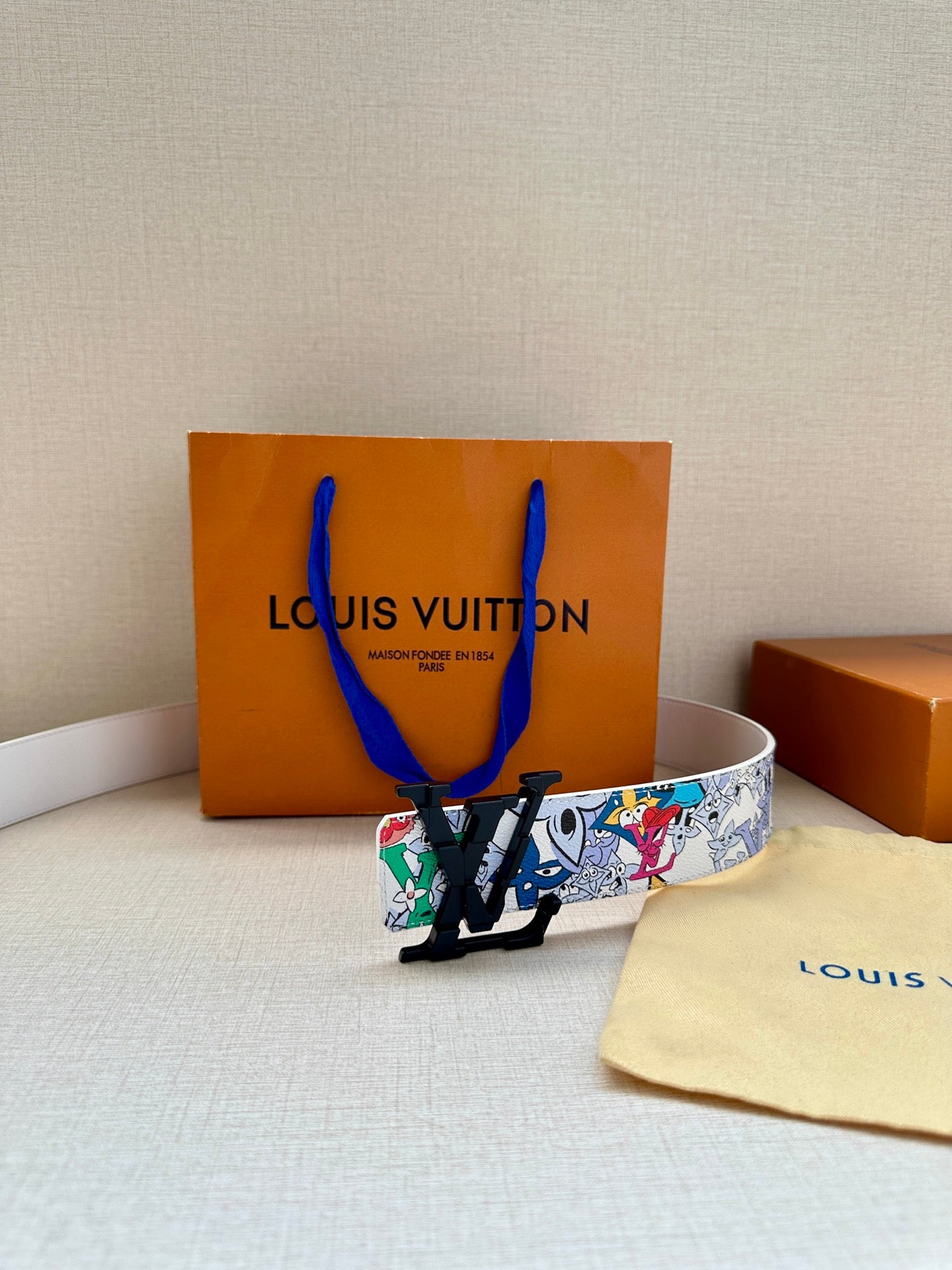 Louis Vuitton belt with white strap and colorful graphic print, black LV buckle