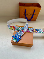 Louis Vuitton belt laid flat: white comic print strap with blue LV buckle