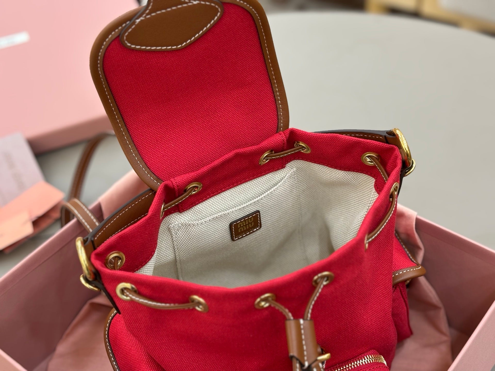 MiuMiu red mini bucket bag open top with cream lining and logo patch