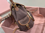 MiuMiu dark gray mini bag side view with adjustable strap, brown trim, gold hardware