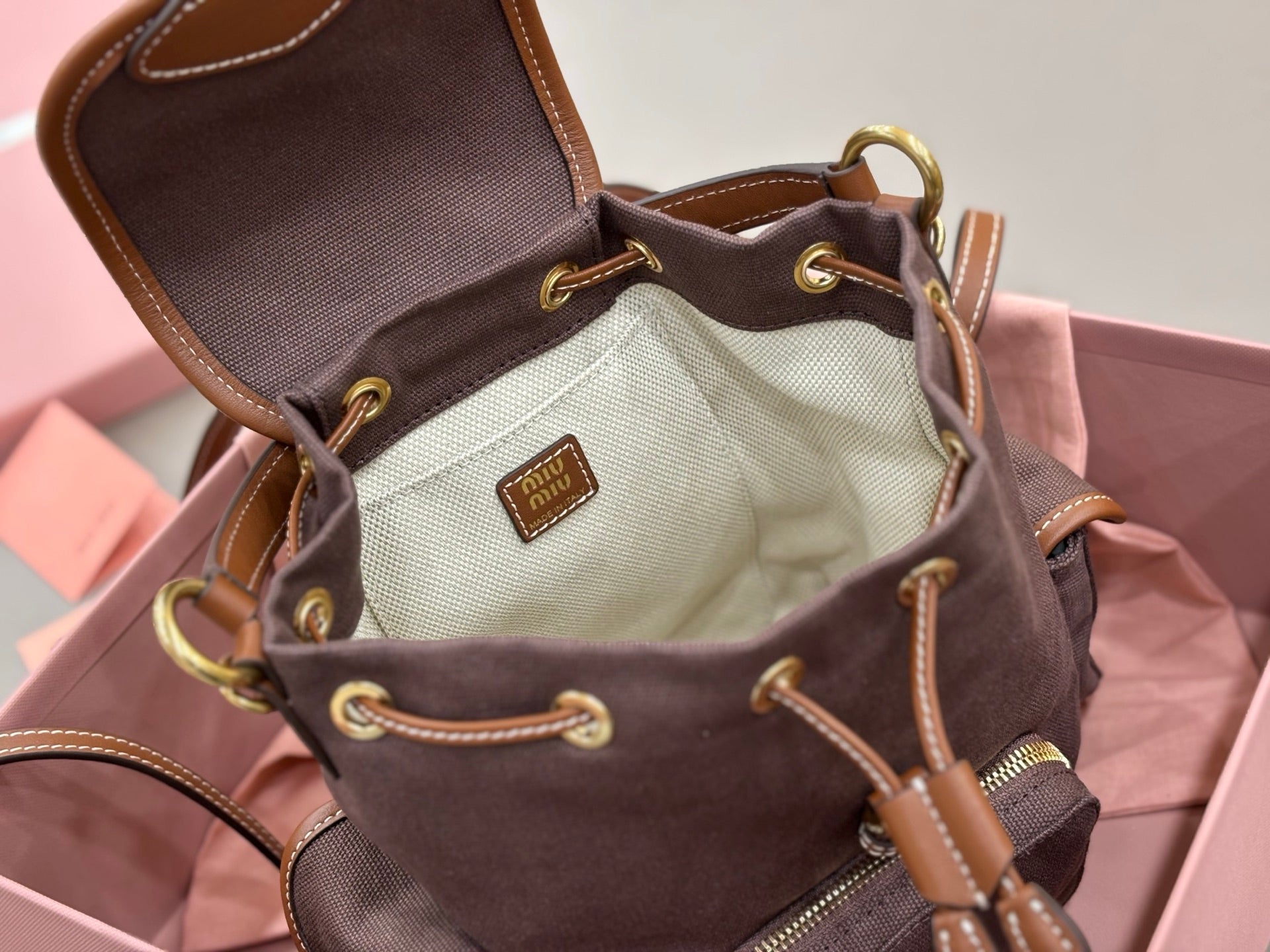 MiuMiu dark gray mini bag open top with cream interior lining and leather drawcords