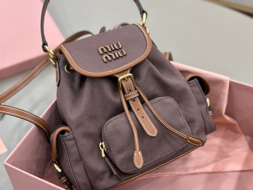 MiuMiu dark gray mini bag close-up with front flap logo and leather drawstring