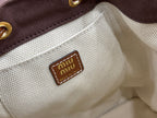 MiuMiu logo patch on cream interior lining of dark gray mini bag