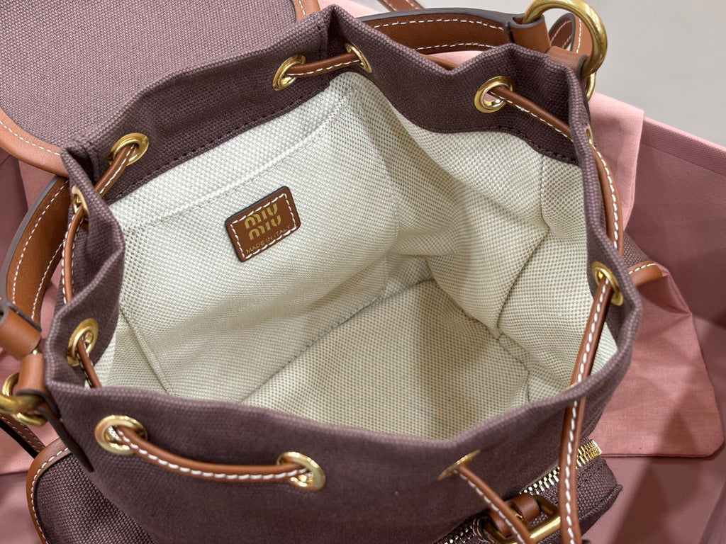 MiuMiu dark gray mini bag open showing cream fabric interior and leather trim