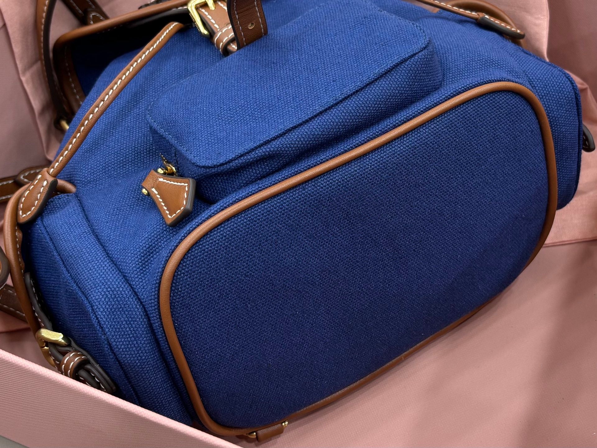 Miu Miu mini backpack blue with front patch pocket, brown piping, and gold accents
