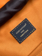 Louis Vuitton made in France leather label on orange fabric lining