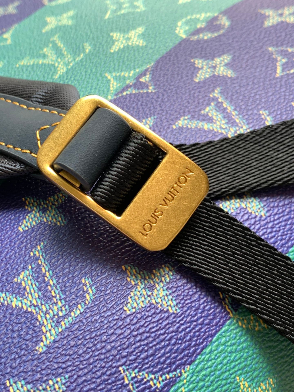 Louis Vuitton gold-tone buckle on black strap over multicolor monogram fabric