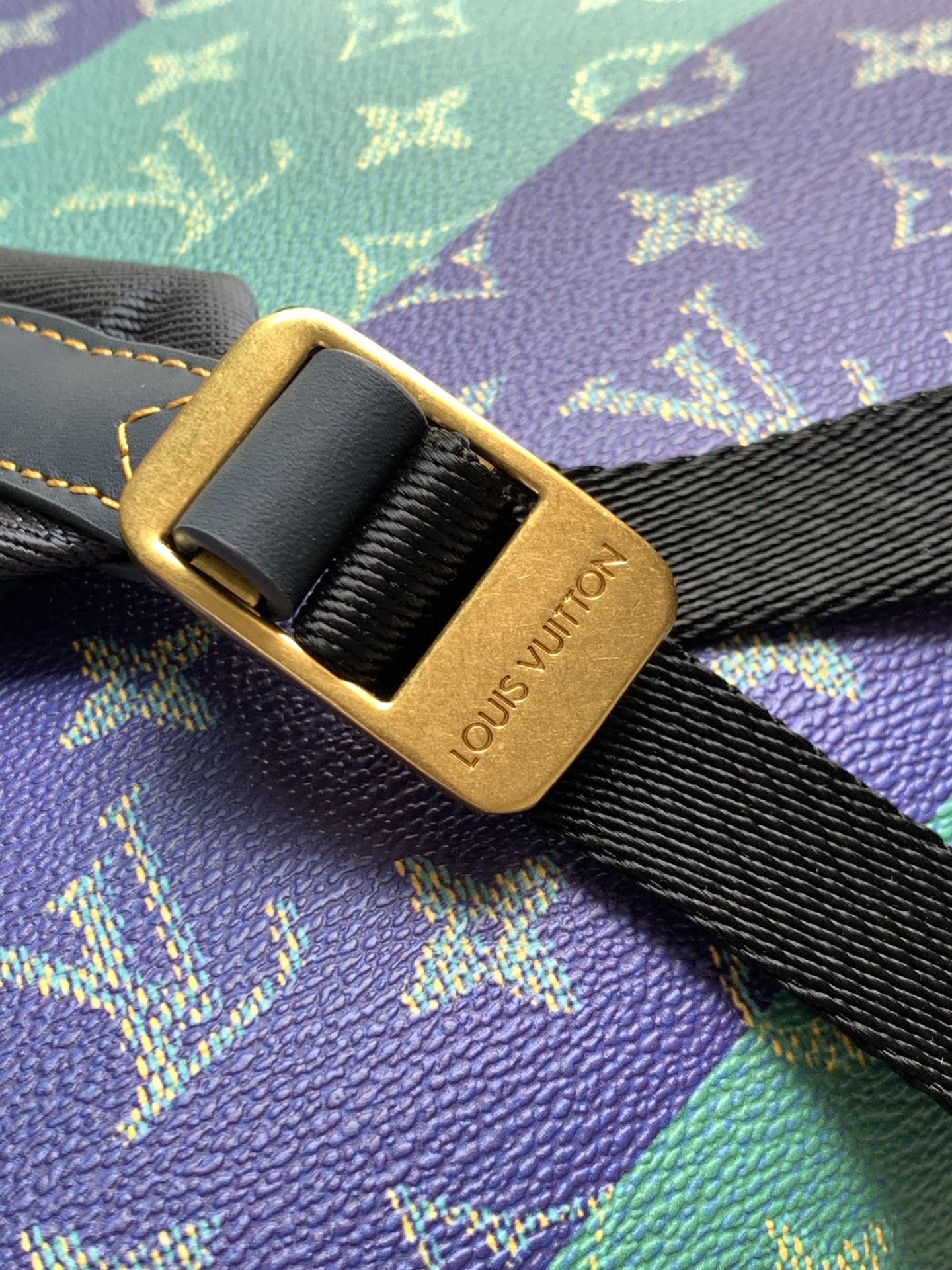 Louis Vuitton gold-tone buckle on black strap over multicolor monogram fabric