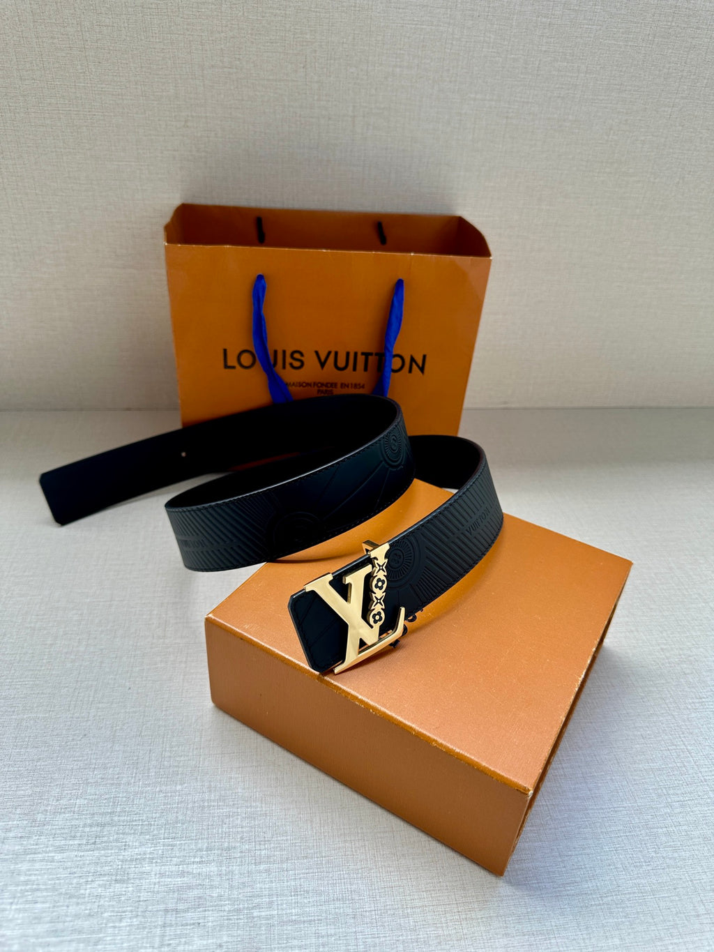 Louis Vuitton belt on box: dark blue strap with gold-tone LV-style buckle