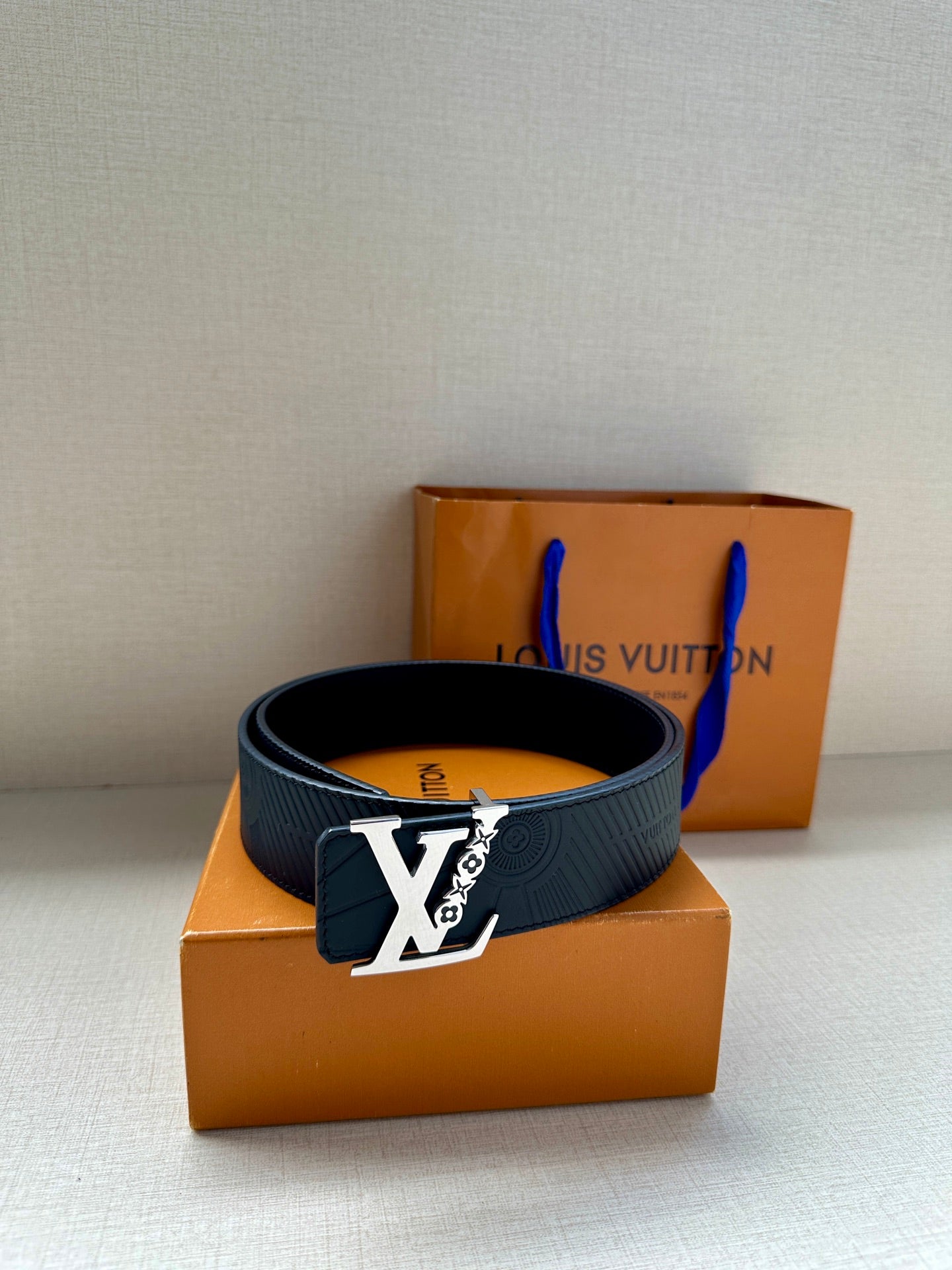 Louis Vuitton belt on box: dark blue embossed strap with gold-tone buckle and blue lining