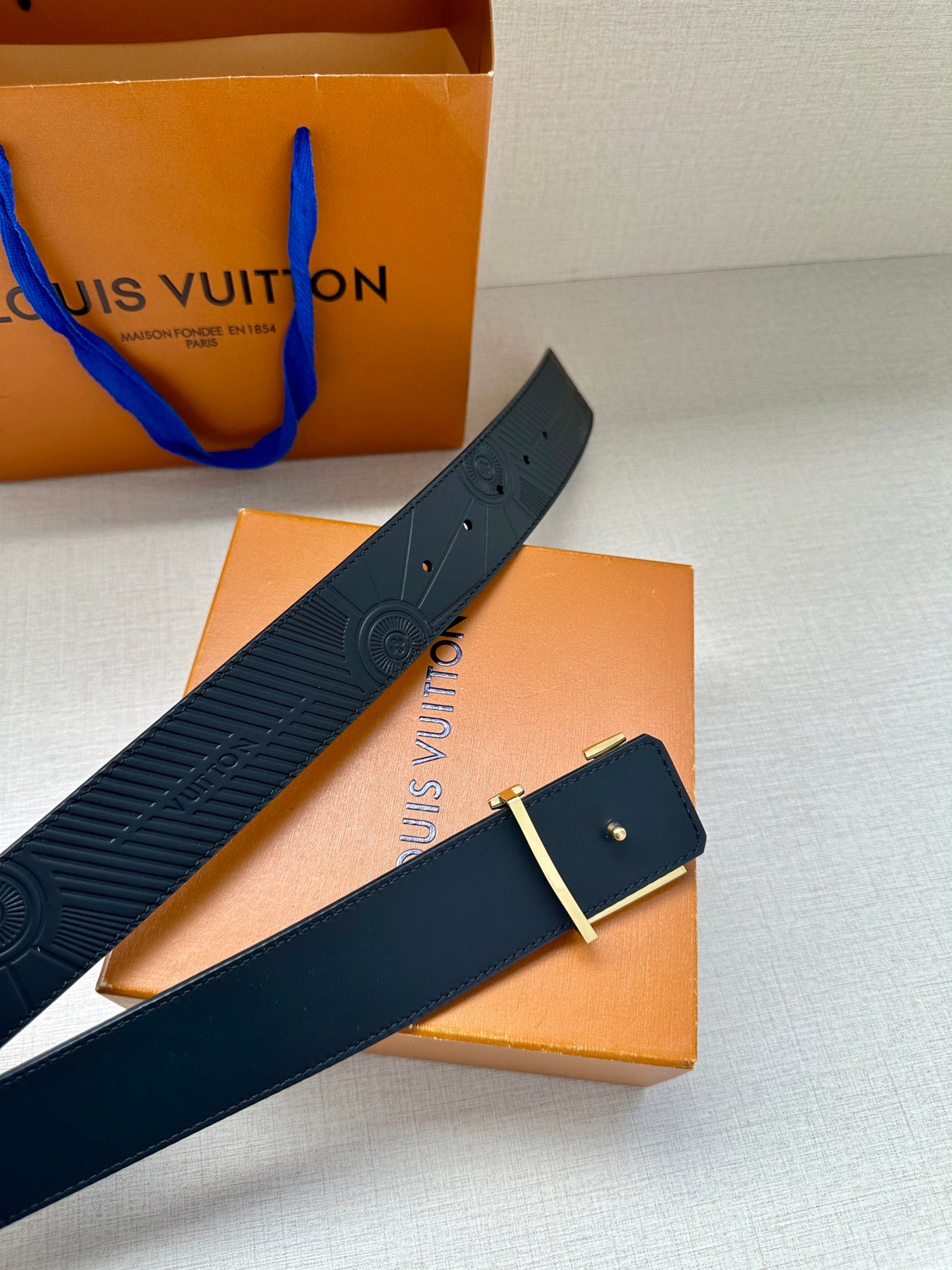 Louis Vuitton belt with dark blue strap and rectangular gold-tone buckle