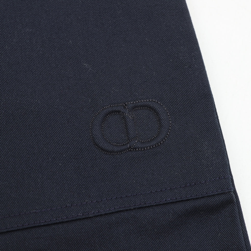 Dark navy stitched monogram patch on pant leg