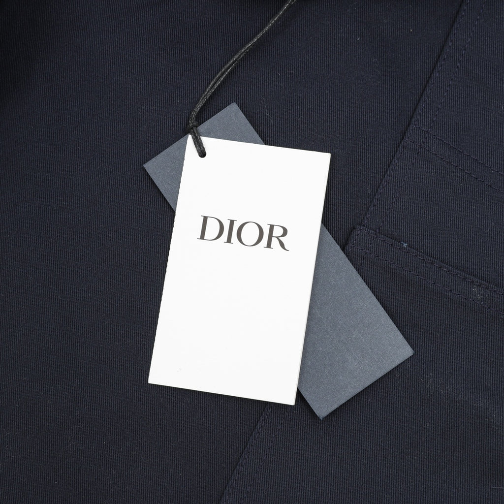 Dior pants garment tag attached to dark navy fabric