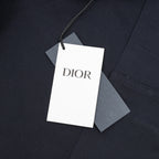 Dior pants garment tag attached to dark navy fabric