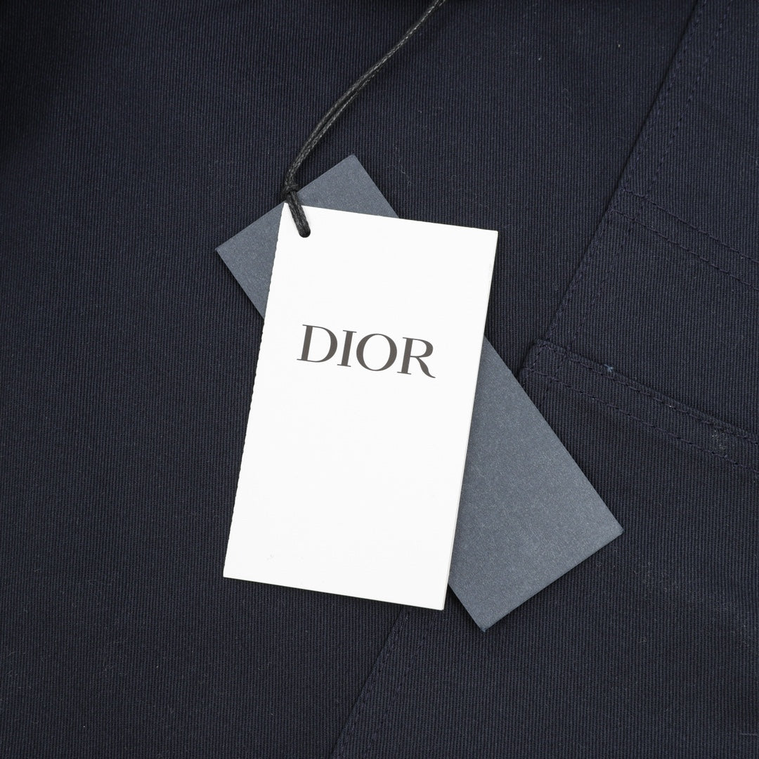 Dior pants garment tag attached to dark navy fabric