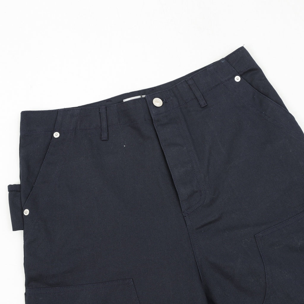 Dark navy pants close-up of front waistband and buttoned fly