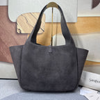 Black suede tote bag with structured shape, top handles, and vertical zipper tab