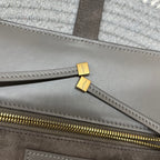 Gray leather tote with gold zipper track and small gold logo hardware tabs