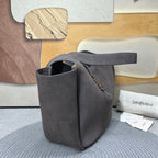 Dark gray suede tote bag shown from side with top handles and gold zipper detail