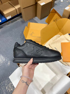 Black leather sneakers with lace-up top, embossed side emblem, and grippy sole