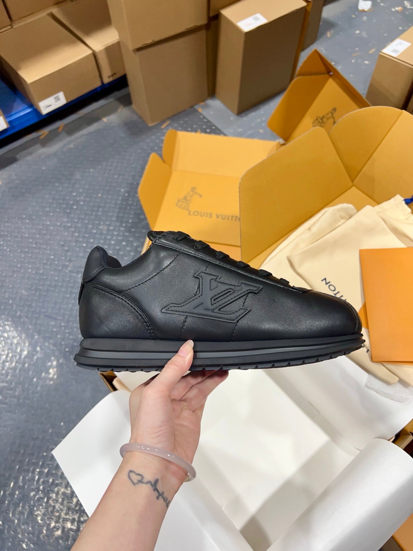 Black leather sneakers with lace-up top, embossed side emblem, and grippy sole