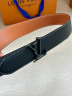Louis Vuitton belt buckle on dark blue leather strap with white edge stitching.