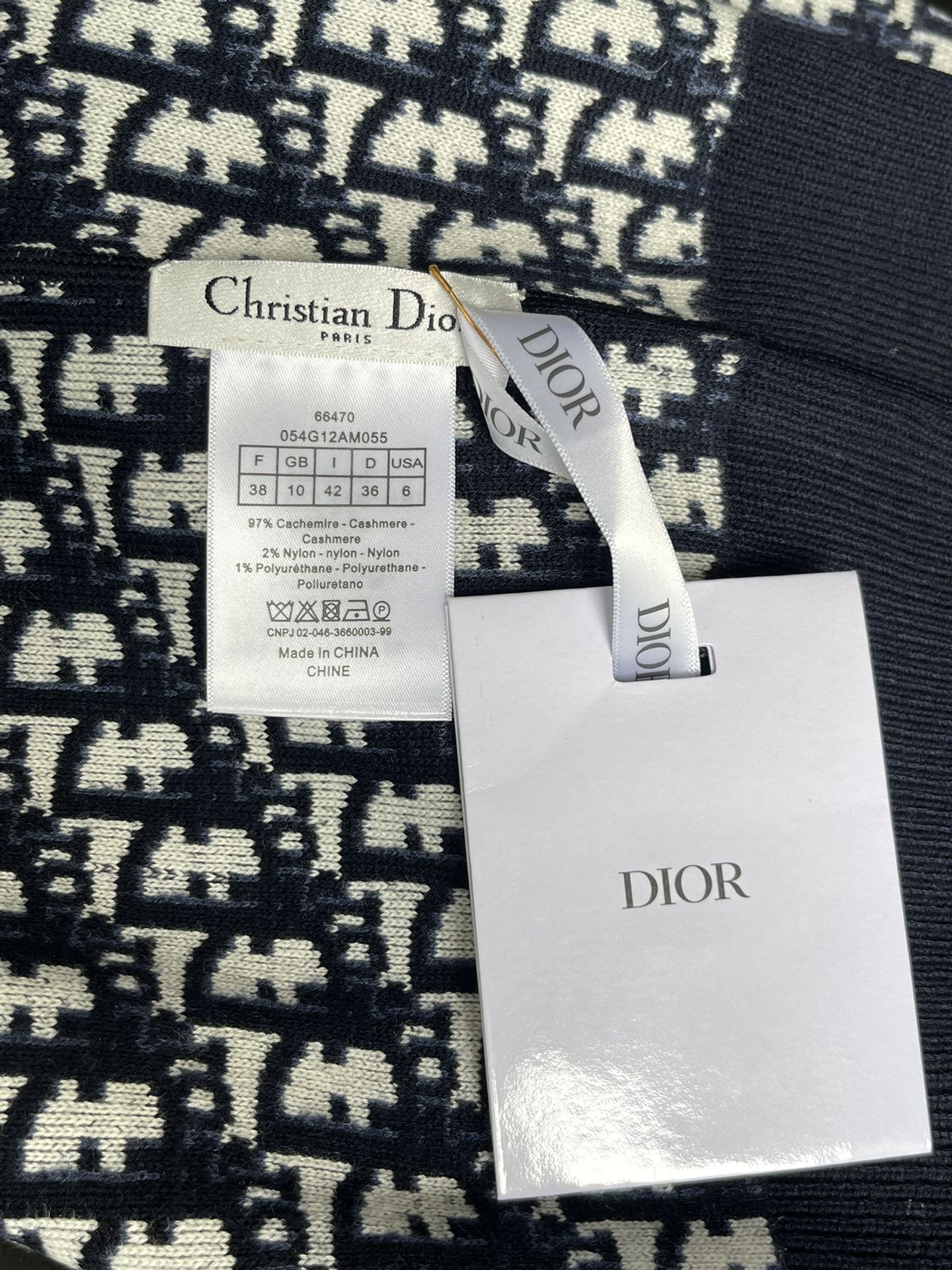 Dior long-sleeve sweater with size label and Dior brand tag attached