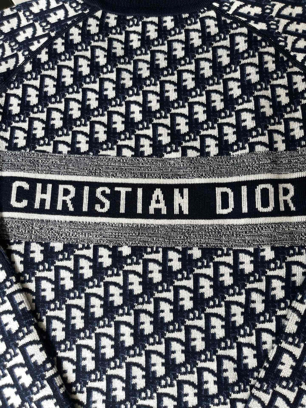 Dior long-sleeve sweater close-up with 'CHRISTIAN DIOR' logo band detail
