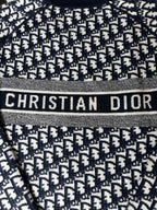 Dior long-sleeve sweater close-up with 'CHRISTIAN DIOR' logo band detail