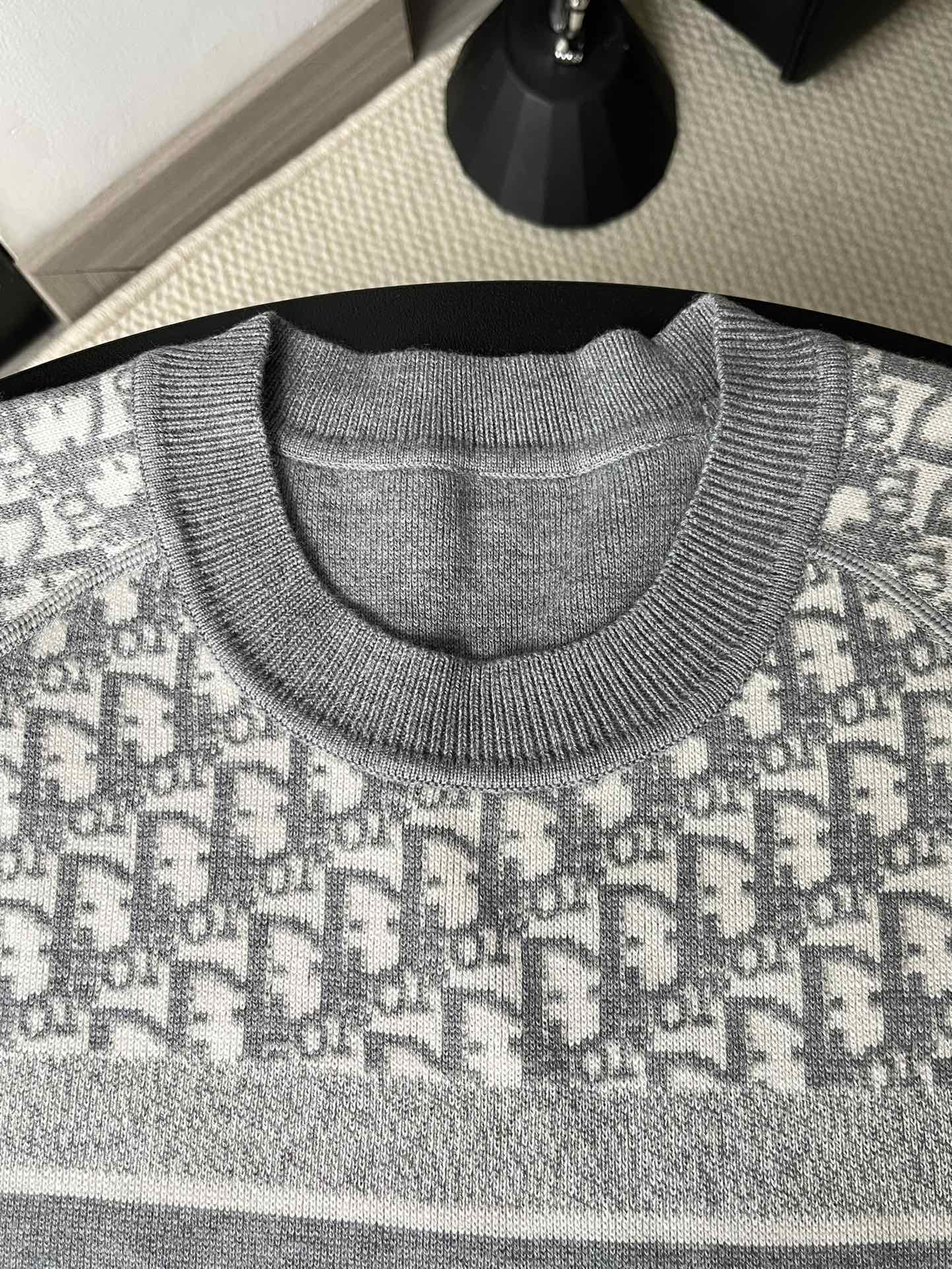 Gray crewneck sweater close-up with ribbed collar and knit texture