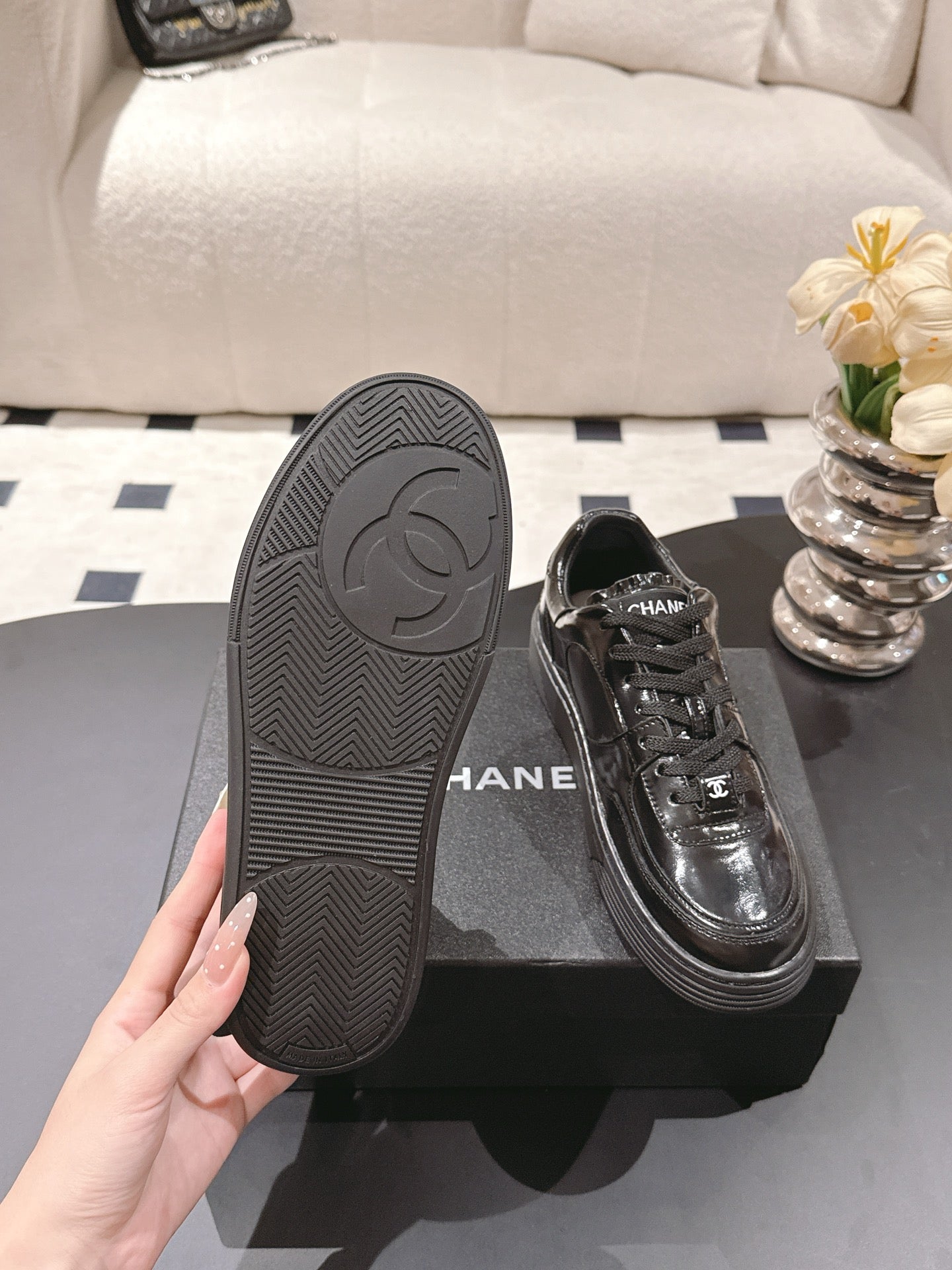 Black sneaker outsole with textured tread and side Chanel emblem