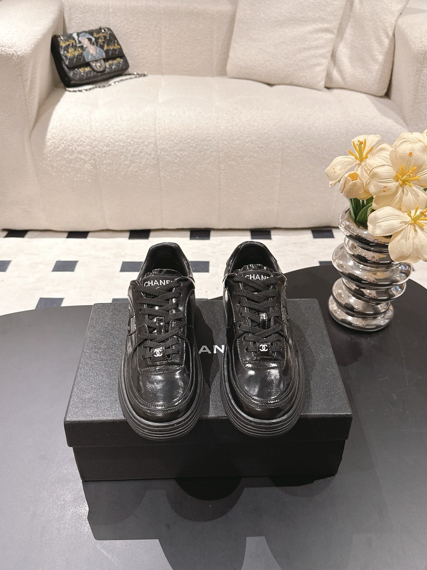Black leather lace-up sneakers with Chanel logo detail on sides
