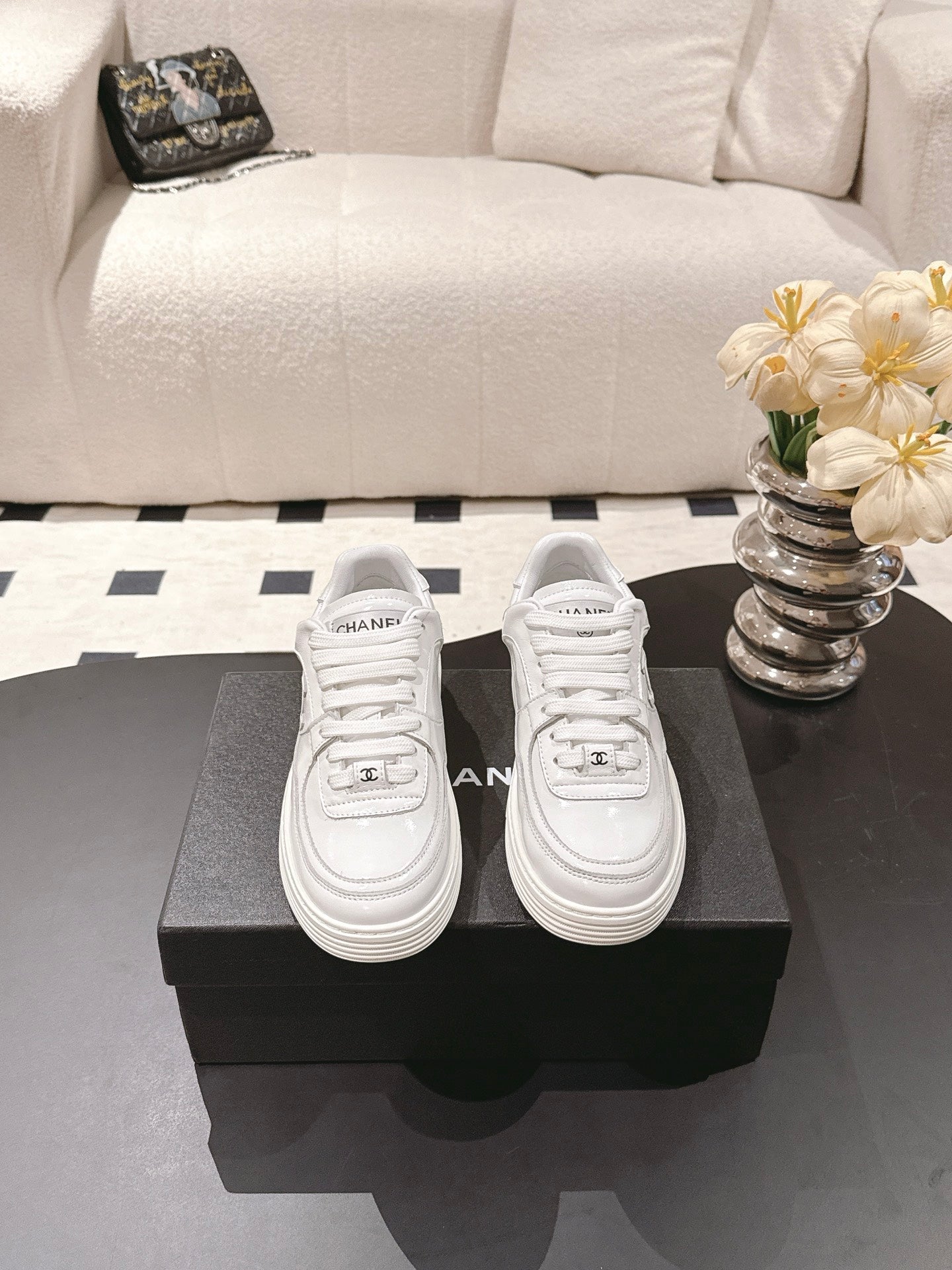 White Chanel sneakers pair with lace-up design and front CHANEL patch