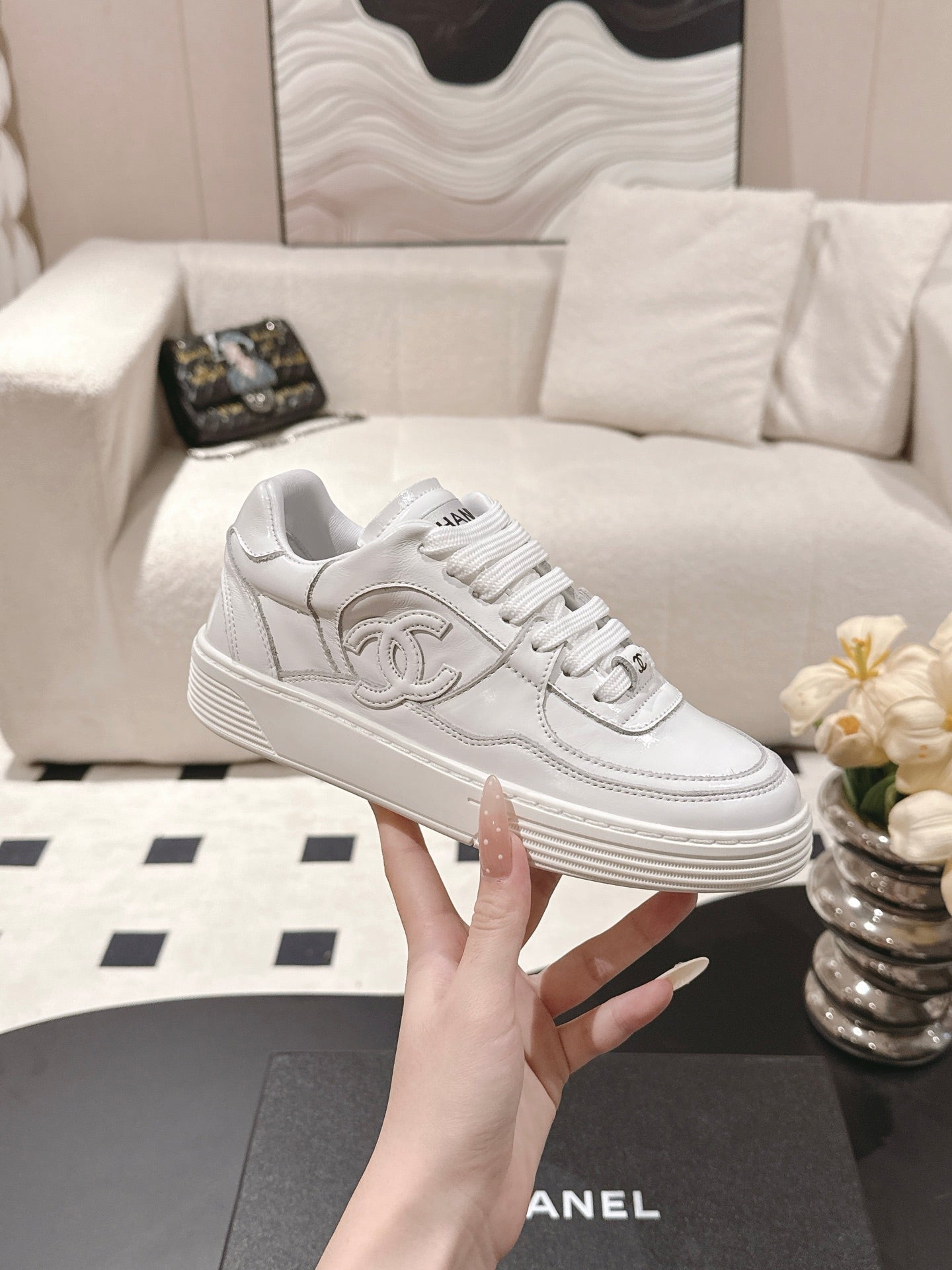 White Chanel low-top sneakers with CC emblem and lace-up front