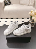 White Chanel low-top sneakers with lace-up closure and CHANEL logo on tongue