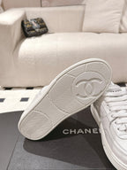 White sneaker outsole close-up with herringbone tread and circular emblem