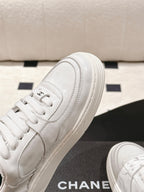 White sneaker side view with stitched panels, laces, and platform sole edge