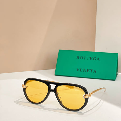 Black cat-eye sunglasses with gold temples and yellow tinted lenses