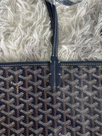 Goyard crossbody bag front, dark monogram pattern with stitched trim and logo