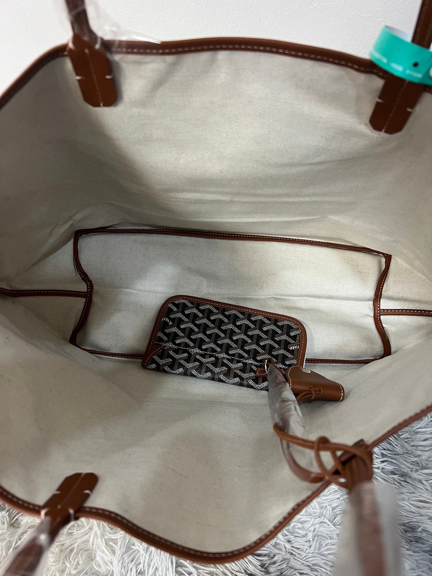 Goyard tote bag interior with small pouch insert and brown leather edging, open