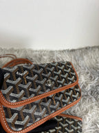 Goyard monogram pouch with brown leather trim, dark fabric and small top strap