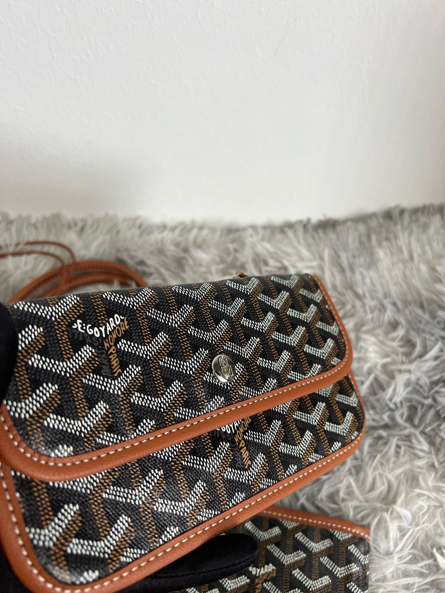 Goyard monogram pouch with brown leather trim, dark fabric and small top strap